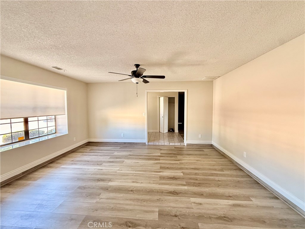 14890 Apple Valley Road Apple Valley, CA 92307 - Photo 4 of 28 a view of an empty room with a window and wooden floor