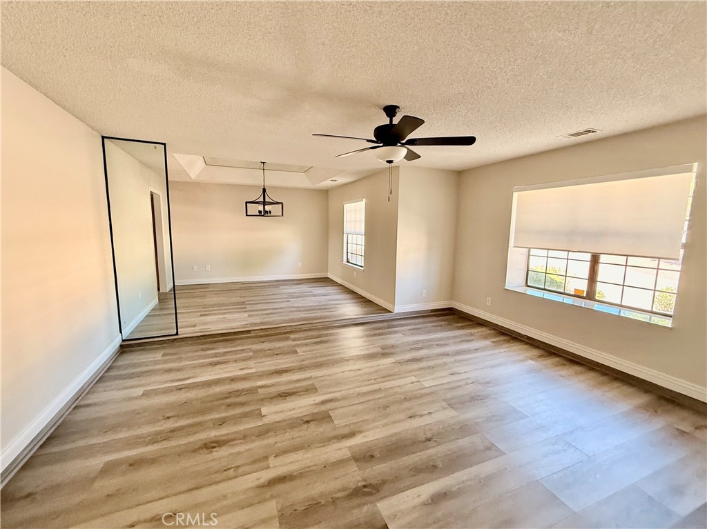 14890 Apple Valley Road Apple Valley, CA 92307 - Photo 5 of 28 wooden floor in an empty room with a window