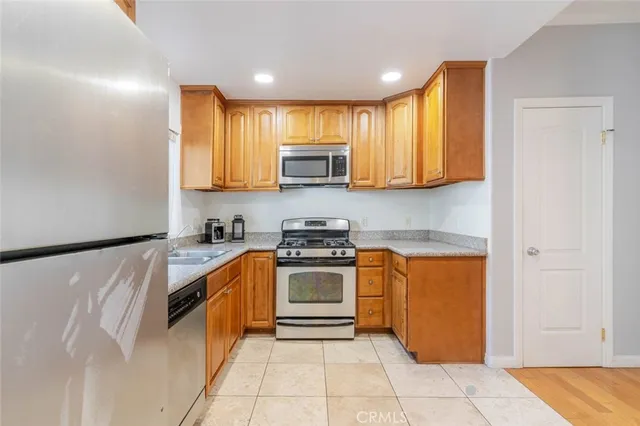 a kitchen with stainless steel appliances granite countertop a stove a sink and a refrigerator