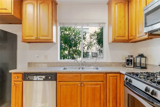 a kitchen with stainless steel appliances granite countertop a sink stove and cabinets