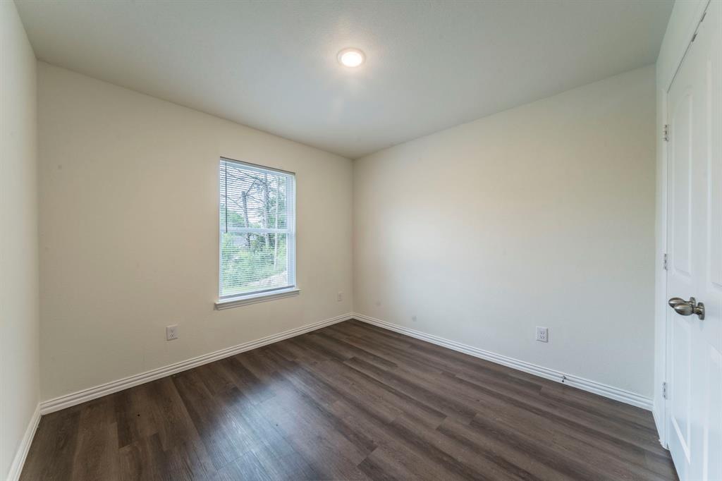 514 East Shepherd Street Denison, TX 75021 - Photo 12 of 16 an empty room with wooden floor and windows