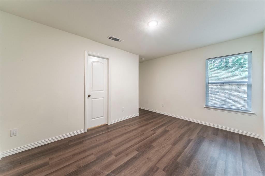 514 East Shepherd Street Denison, TX 75021 - Photo 7 of 16 an empty room with wooden floor and windows