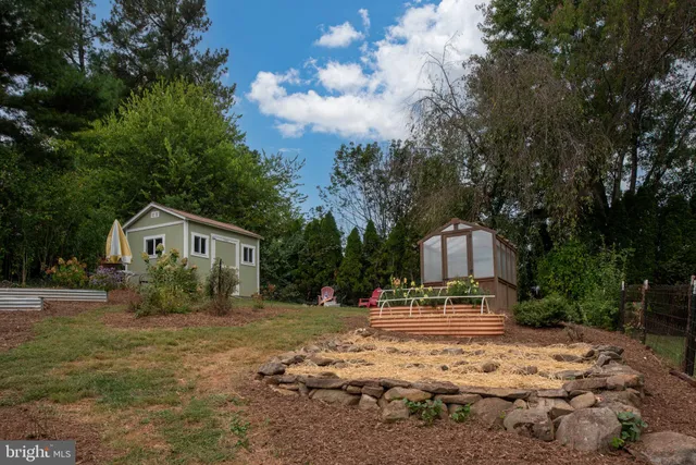 a front view of a house with a yard covered with trees