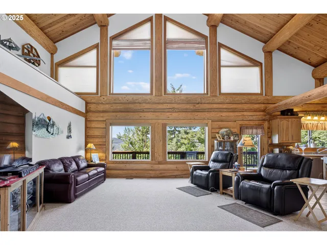 a living room with furniture a large window and flat screen tv
