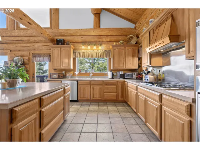 a kitchen with stainless steel appliances kitchen island granite countertop a table chairs and a refrigerator