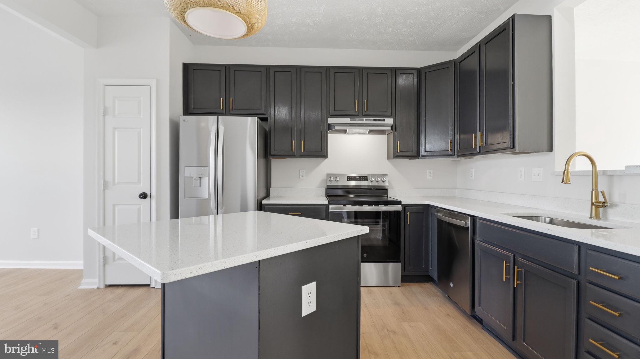 1404 Pangbourne Way Hanover, MD 21076 - Photo 3 of 31 a kitchen with sink a refrigerator and cabinets