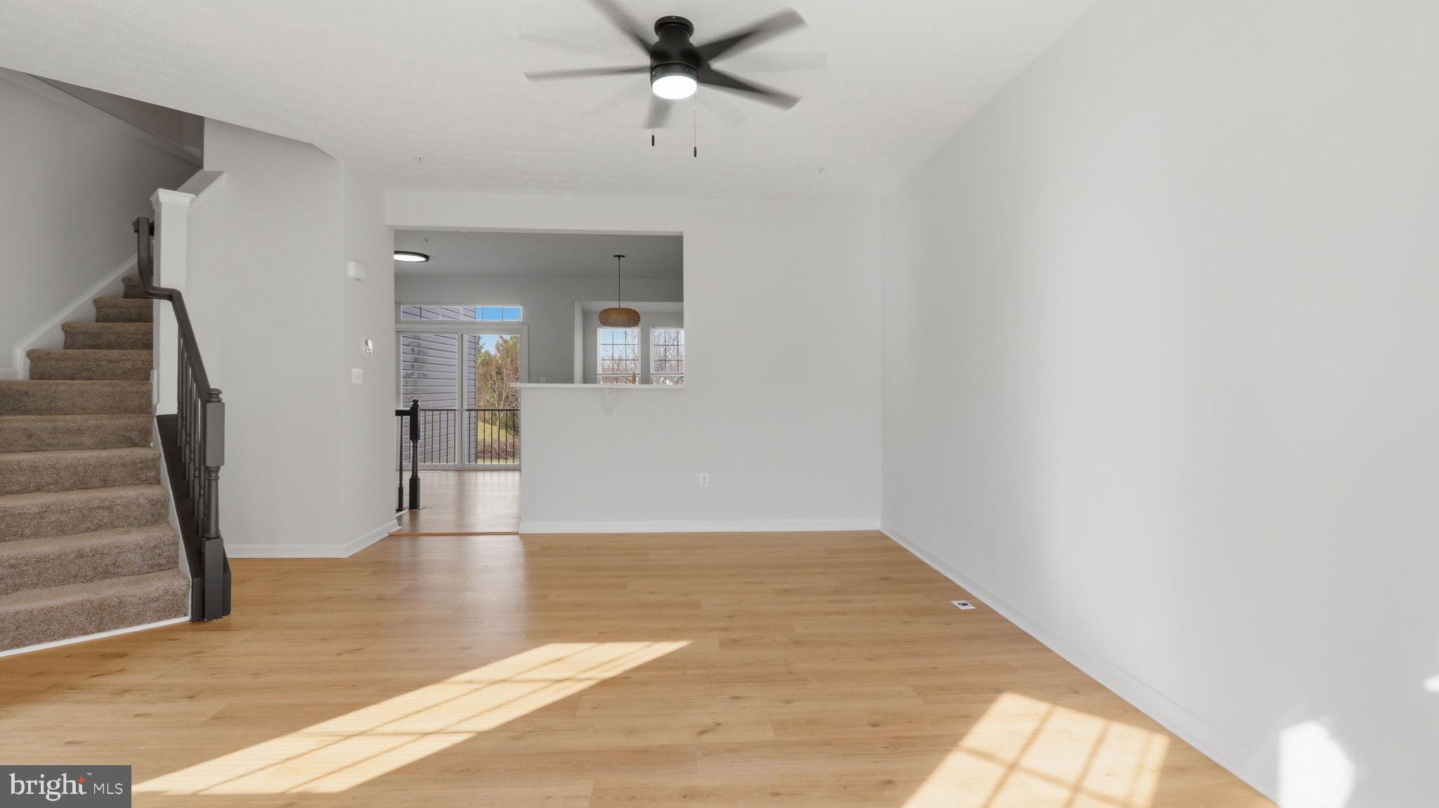 1404 Pangbourne Way Hanover, MD 21076 - Photo 9 of 31 a view of an empty room with wooden floor and a large window