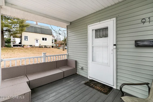 a view of a balcony with two chairs and a rug