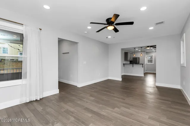 a view of a livingroom with a ceiling fan hardwood floor and a ceiling fan