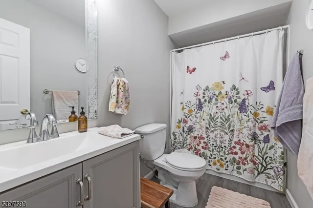 a bathroom with a toilet sink and shower curtain
