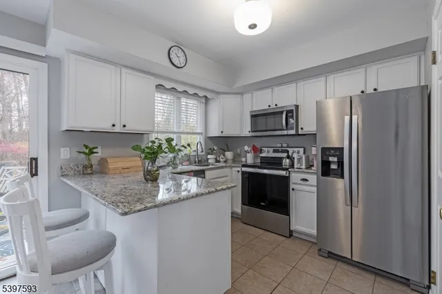 a kitchen with stainless steel appliances granite countertop a refrigerator sink and stove