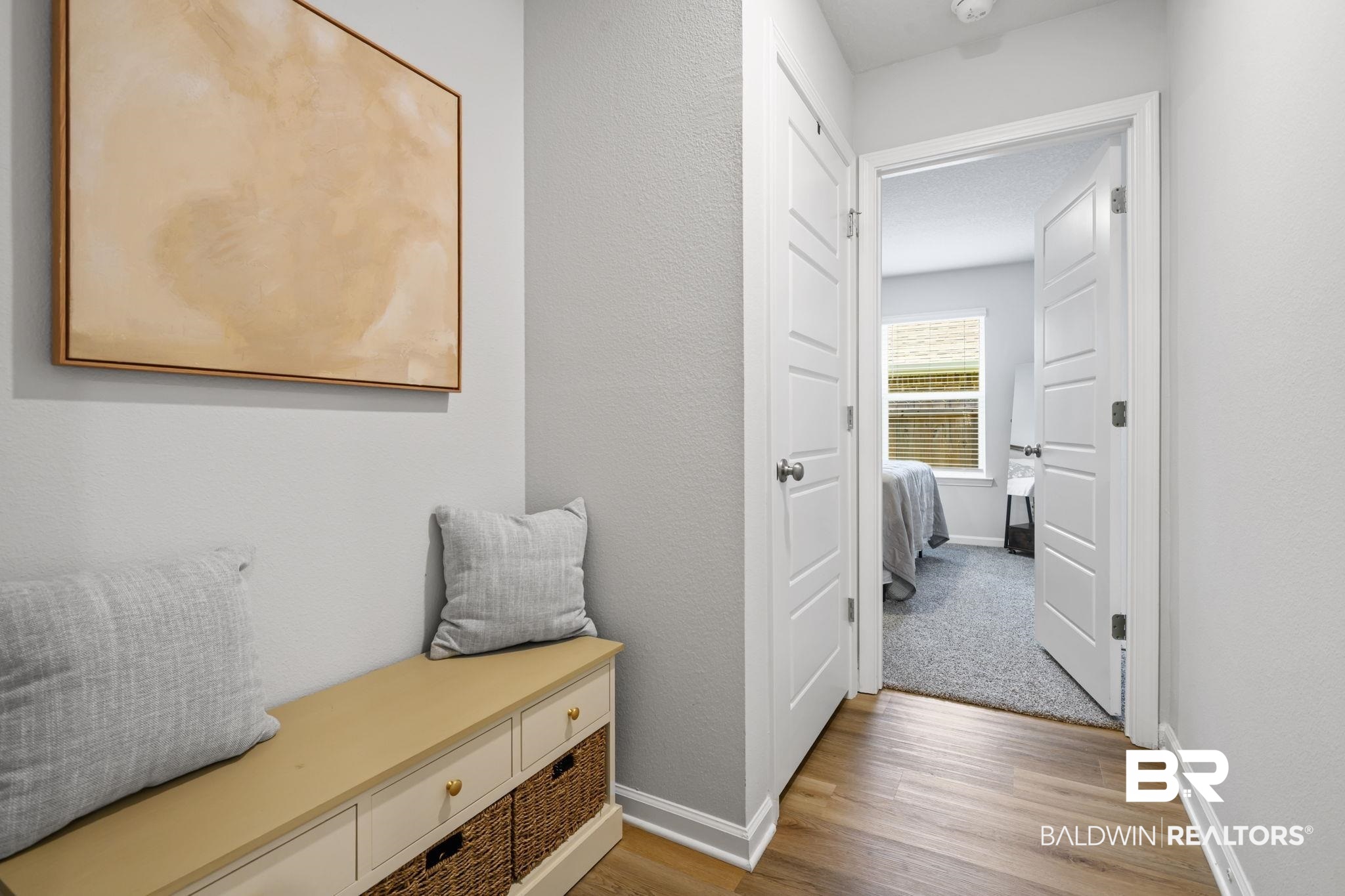 8021 Valor Rdg Way North Mobile, AL 36619 - Photo 11 of 34 Hallway featuring wood-finish flooring, light gray wall paint, and white trim molding