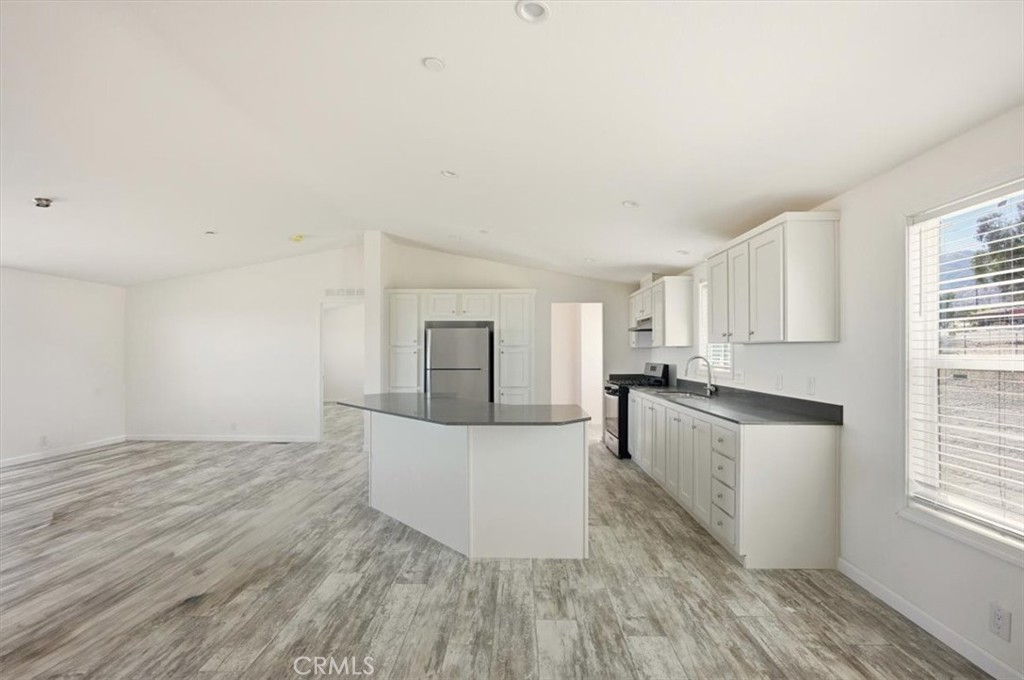 9622 Via Verde Avenue Pinon Hills, CA 92372 - Photo 13 of 48 a living room with stainless steel appliances wooden floors and white walls