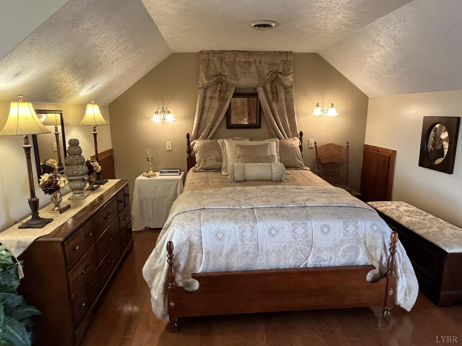 3912 Lowry Road Goode, VA 24556 - Photo 21 of 56 a bedroom with a bed a mirror and lamp