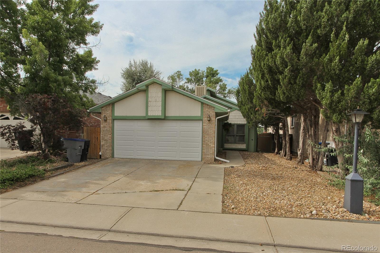 645 Wade Road Longmont, CO 80503 - Photo 1 of 32 a white house that has a tree in front of it