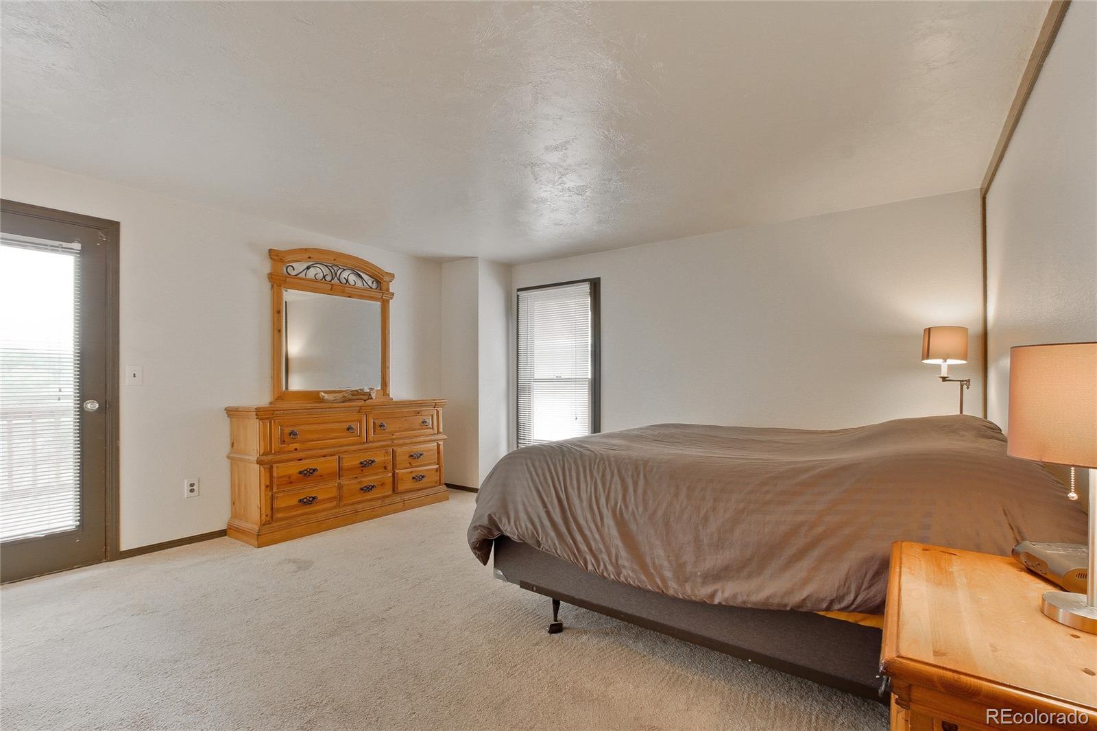 645 Wade Road Longmont, CO 80503 - Photo 11 of 32 a bedroom with a bed and wooden floor