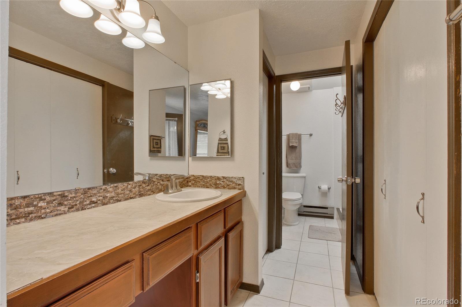 645 Wade Road Longmont, CO 80503 - Photo 16 of 32 a bathroom with a sink vanity granite and a mirror