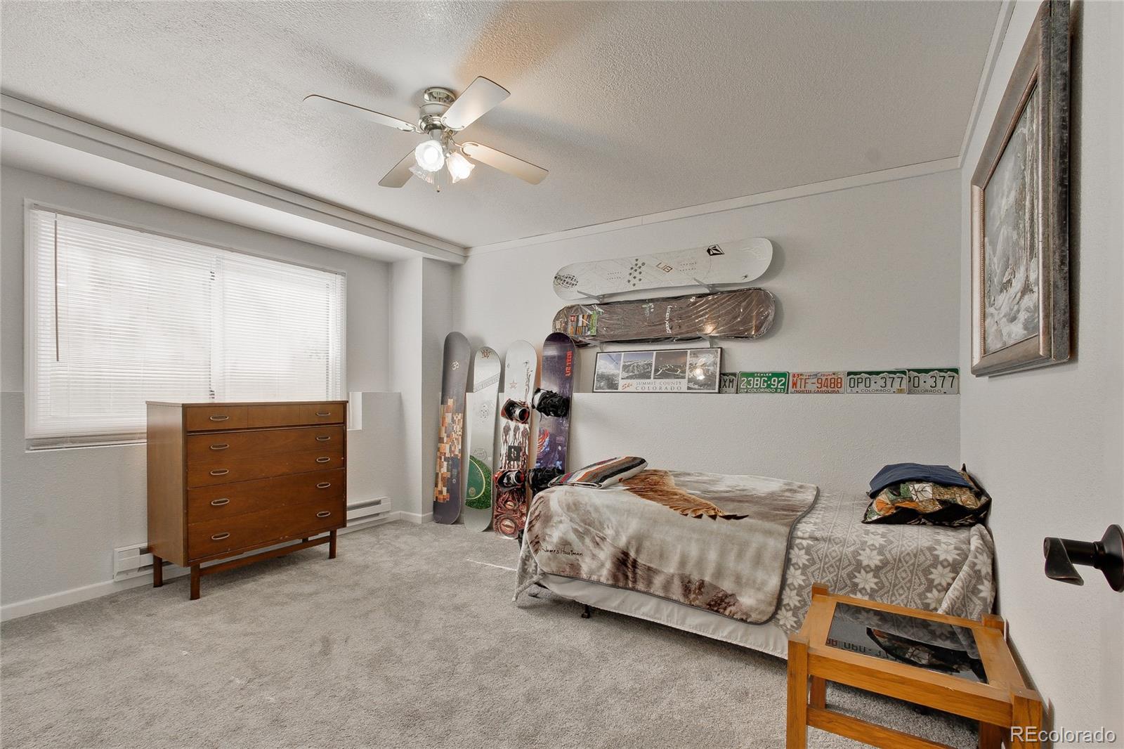 645 Wade Road Longmont, CO 80503 - Photo 23 of 32 a bedroom with furniture and a chandelier fan