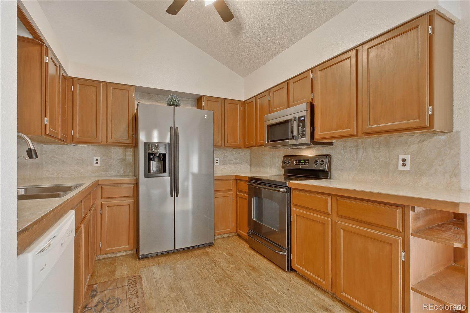 645 Wade Road Longmont, CO 80503 - Photo 10 of 32 a kitchen with stainless steel appliances granite countertop a refrigerator stove top oven and sink