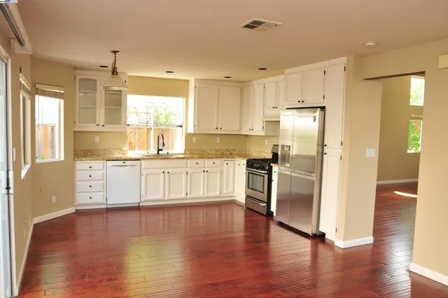 a kitchen with stainless steel appliances a refrigerator and a stove top oven