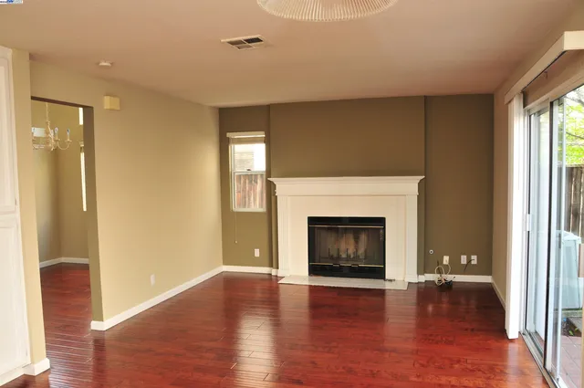 a view of an empty room with window and fire place