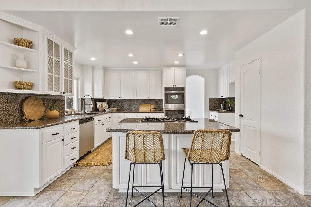 1363 Corte Alveo Oceanside, CA 92057 - Photo 17 of 62 a kitchen with stainless steel appliances granite countertop a stove a sink and a refrigerator
