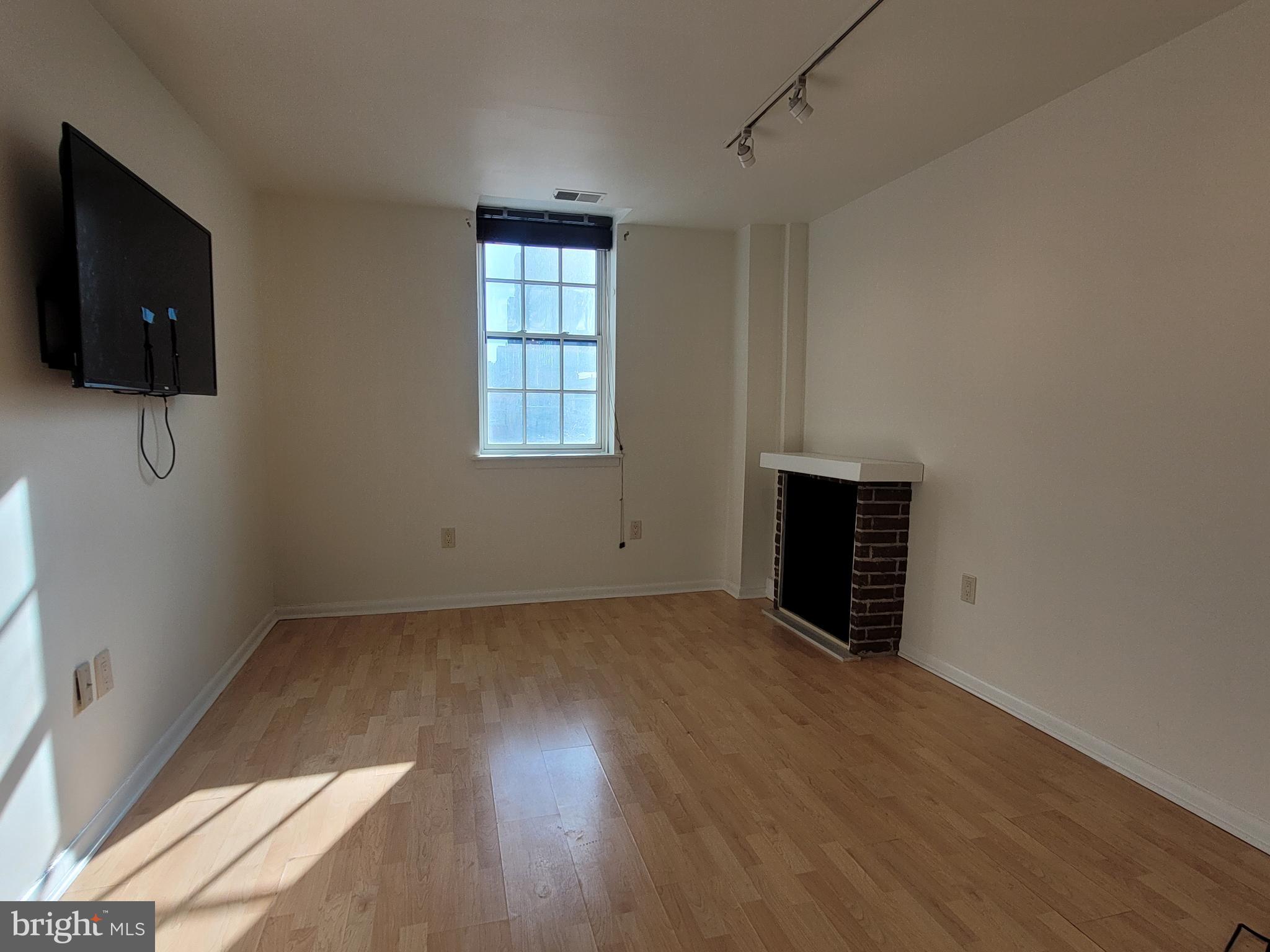 2015 Chestnut Street, Unit 2F Philadelphia, PA 19103 - Photo 3 of 16 an empty room with wooden floor and windows