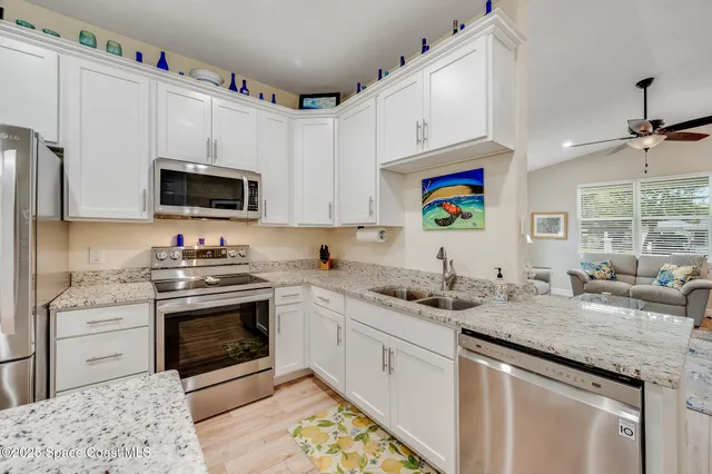 a kitchen with granite countertop a sink a stove a microwave and wooden cabinets