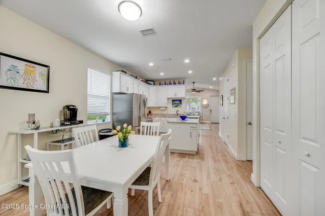 a kitchen with a table chairs refrigerator and microwave
