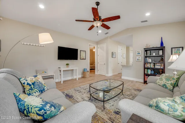 a living room with furniture a flat screen tv and a book shelf