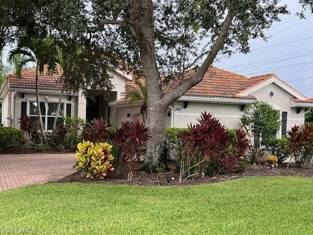 3411 Sandpiper Way Naples, FL 34109 - Photo 25 of 35 a front view of a house with a garden and trees