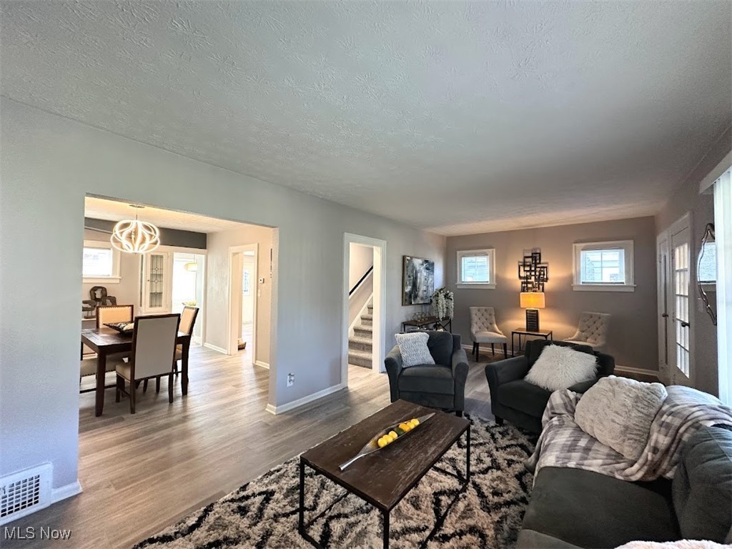 3288 Kildare Road Cleveland, OH 44118 - Photo 5 of 18 Living room featuring wood finished floors, a textured ceiling, stairway, and a chandelier