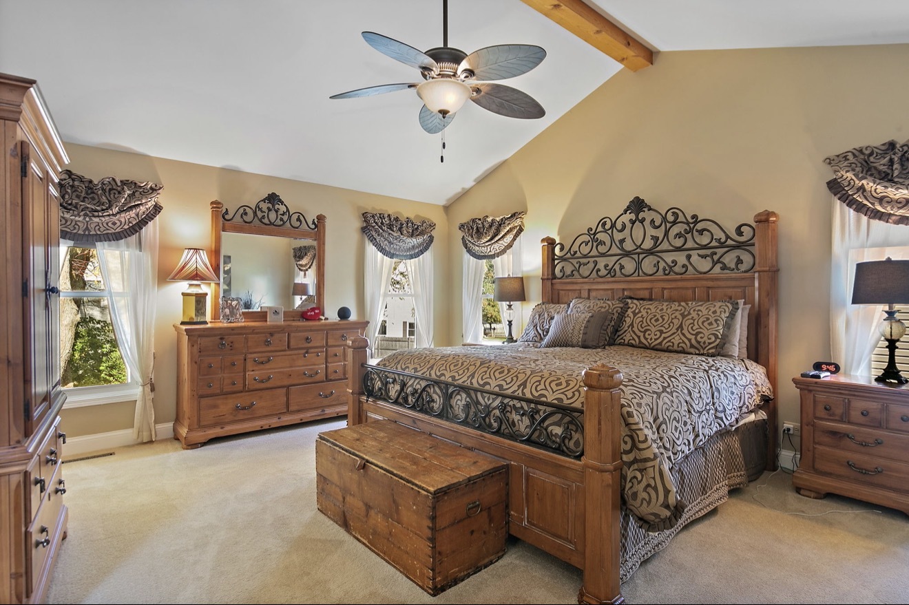11612 Becky Lee Huntley, IL 60142 - Photo 16 of 33 a spacious bedroom with a bed a dresser and a chandelier