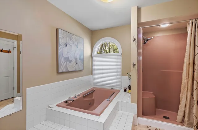 a bathroom with a tub a sink and glass door