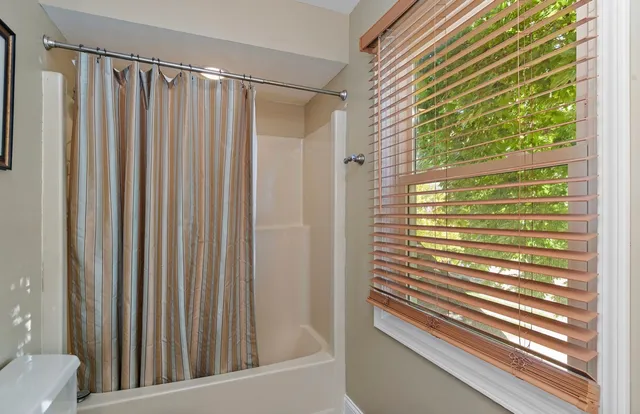a view of a bathroom with shower and a window