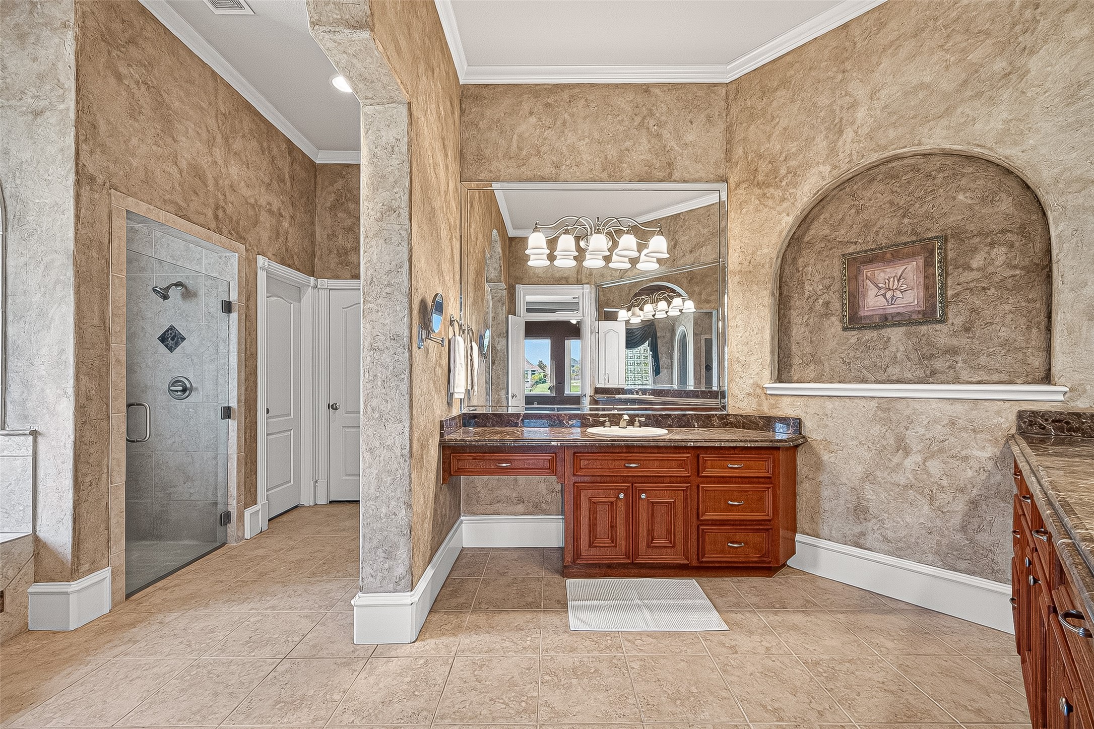 25626 Windy Isle Court Spring, TX 77389 - Photo 18 of 45 This spacious bathroom with large mirrors, stylish lighting, and a dual-sink vanity with rich wood cabinetry and classic textured walls offers a luxurious and inviting atmosphere.