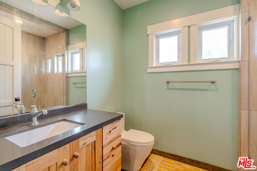 5903 Tellefson Road Culver City, CA 90230 - Photo 24 of 38 a bathroom with a granite countertop sink toilet and a mirror