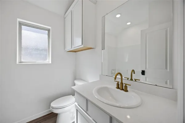 a bathroom with a sink toilet and a mirror
