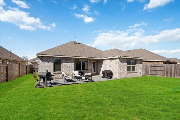 a front view of a house with garden and trees