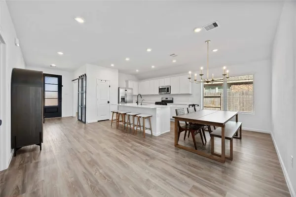 a kitchen with stainless steel appliances kitchen island granite countertop a dining table chairs and granite counter tops