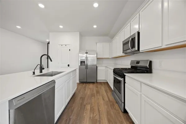 a kitchen with stainless steel appliances granite countertop a sink stove and cabinets