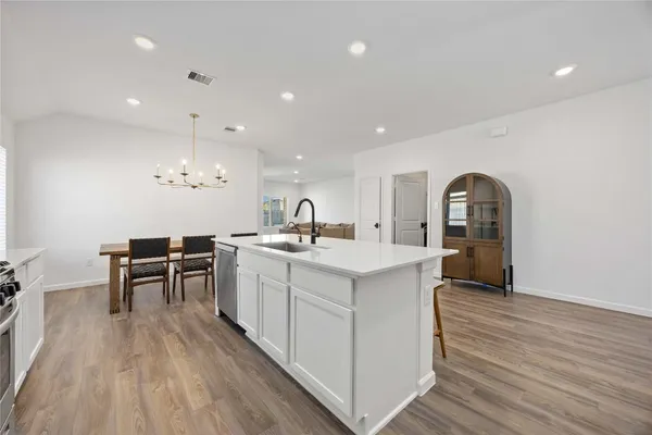 a kitchen with a sink appliances and wooden floor