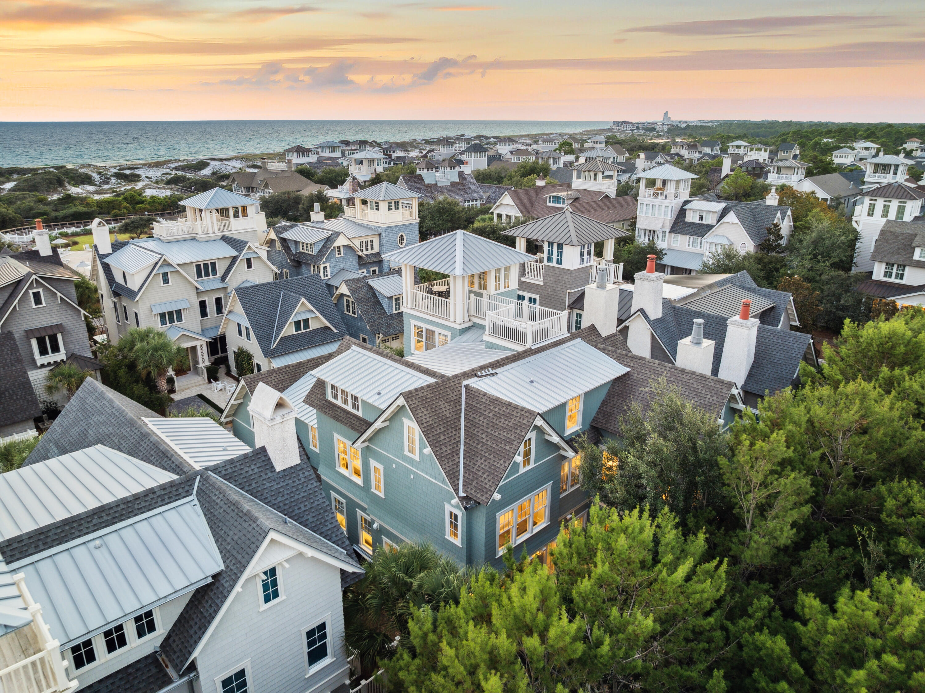 an aerial view of a residential apartment building with a yard and mountain view in back