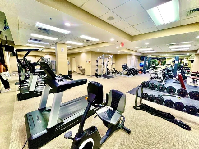 a view of a hallway with wooden floor and a bathroom