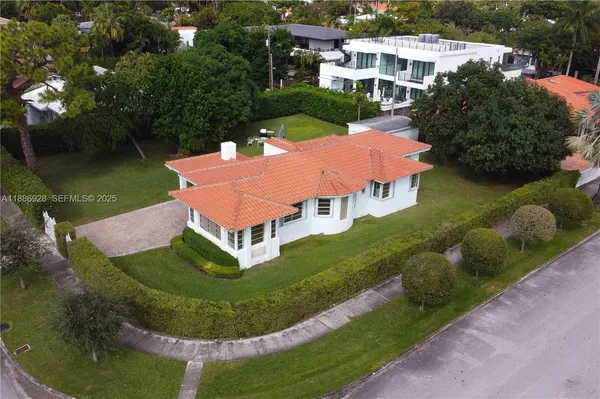 an aerial view of a house with swimming pool a patio and yard