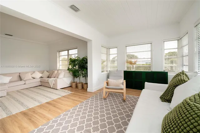 a living room with furniture lamp and large window