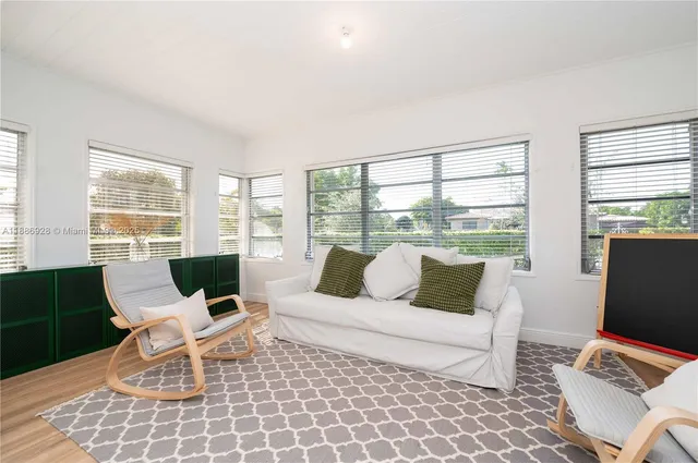 a living room with furniture and floor to ceiling windows
