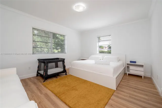 a spacious bedroom with a bed a table and window