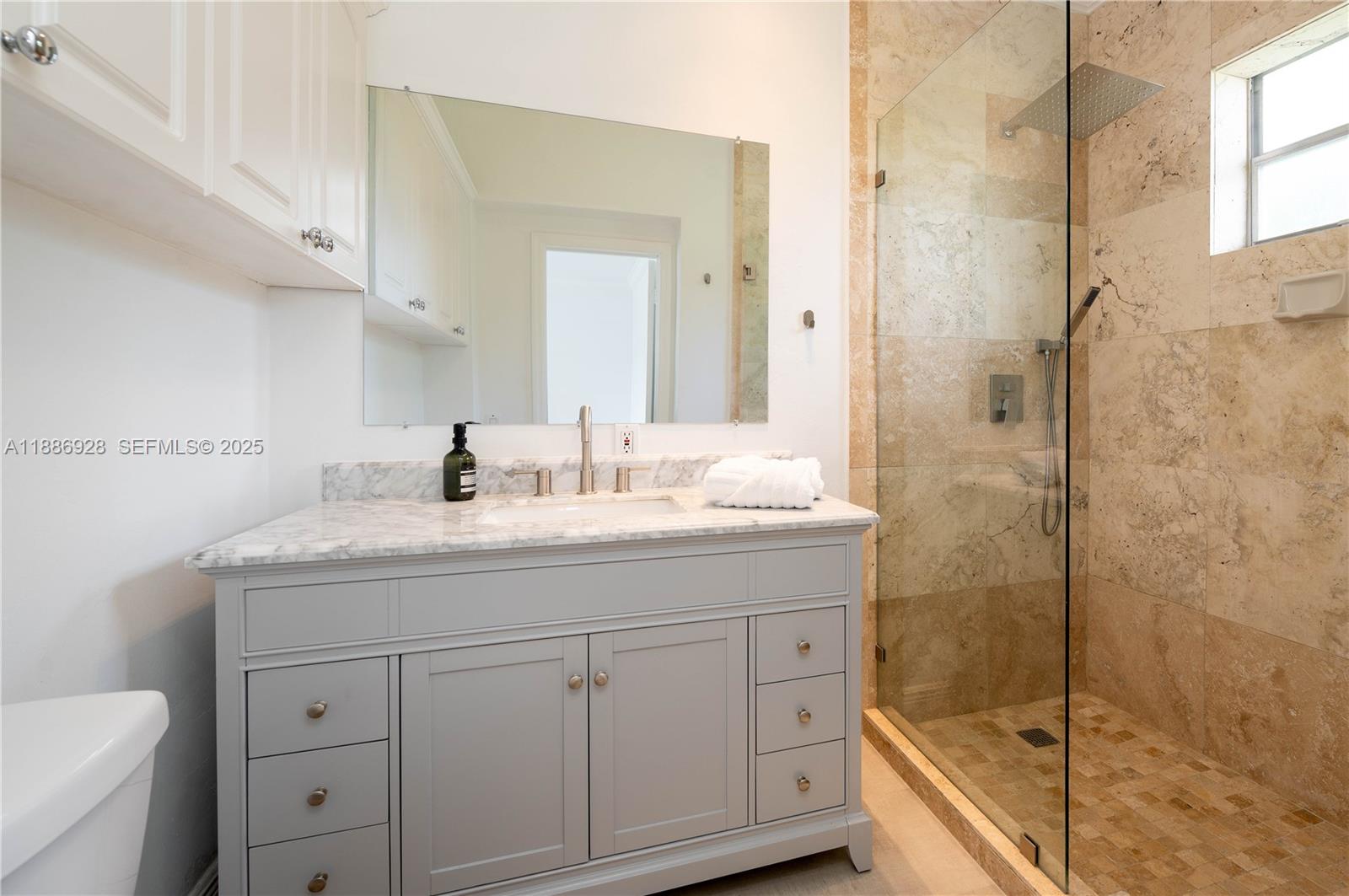 501 Southwest 24th Road, Unit 501 Miami, FL 33129 - Photo 17 of 29 a bathroom with a granite countertop sink a toilet and shower