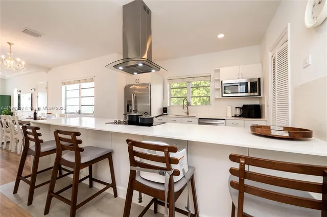 a kitchen with a dining table chairs and white cabinets